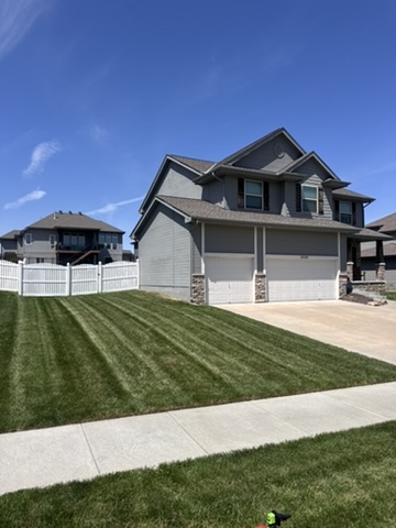 Large two-story home with freshly mowed lawn and striping